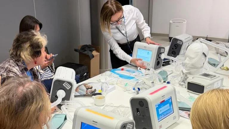 Na zdjęciu znajdują się uczestnicy szkolenia "Podstawy Nieinwazyjnej Wentylacji Mechanicznej". Są w trakcie warsztatów z respiratorów Philips.