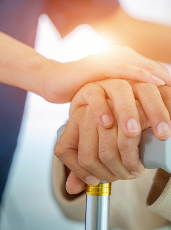 Pielęgniarka trzyma za rękę starszego mężczyznę