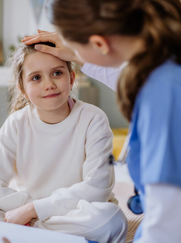 Young doctor taking care of little girl in hospital room
